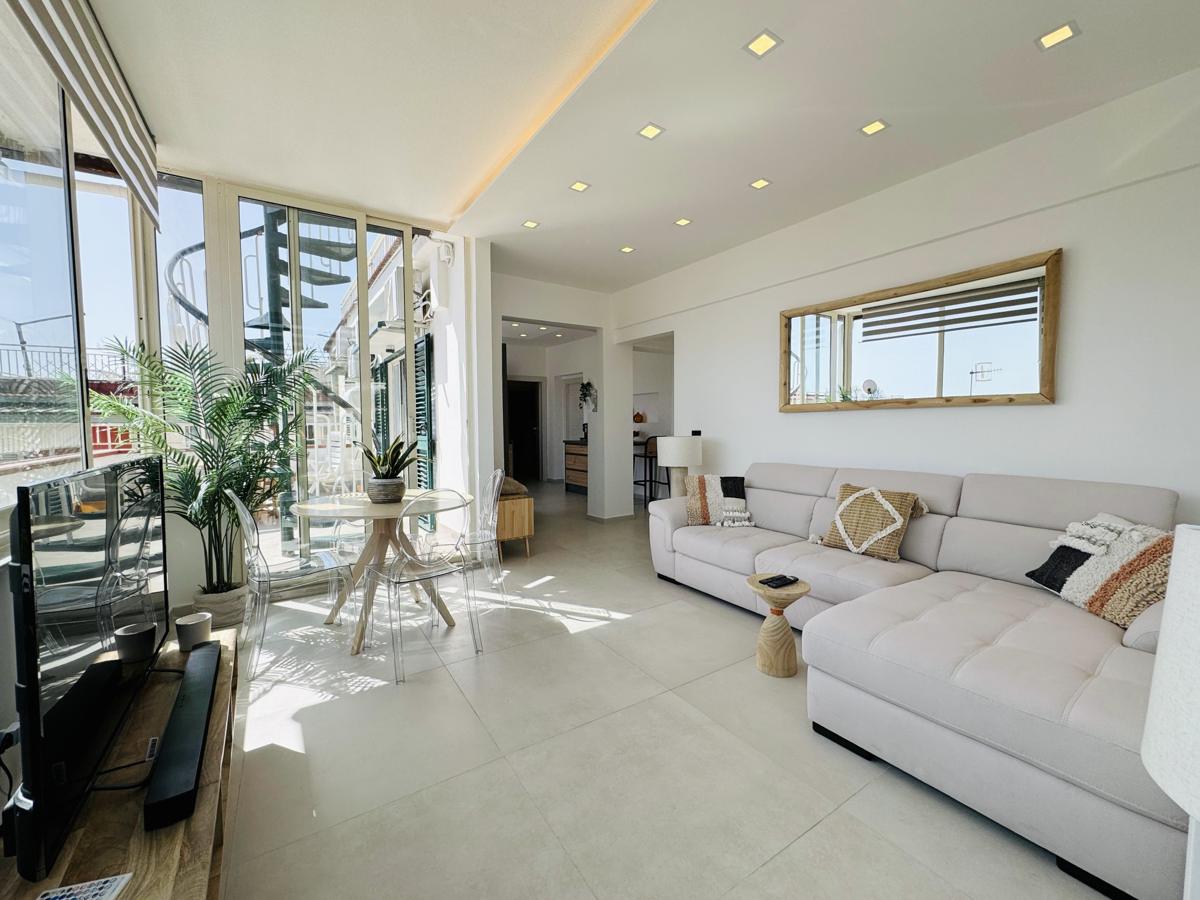 Elegant living area of Terrazza Iside luxury penthouse with sea-facing windows, Pozzuoli waterfront, Italy